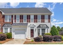 Charming townhome with a front-facing garage, complemented by lush landscaping at 4039 Holly Villa Cir, Indian Trail, NC 28079