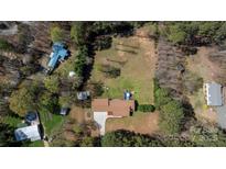 Expansive aerial view of a home with a large yard, mature trees, and a detached garage, offering privacy and space at 4487 Catawba Burris Rd, Denver, NC 28037