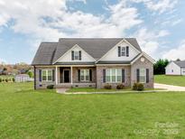 Charming single-Gathering home with a well-manicured lawn and a classic brick facade under a cloudy sky at 514 Baucom Deese Rd, Monroe, NC 28110