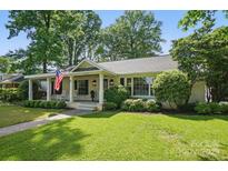 Charming single-story house featuring a covered porch with rocking chairs and swing at 5400 Glenham Dr, Charlotte, NC 28210