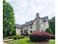 Beautiful two-story home featuring a stone chimney and lush landscaping in a well-manicured yard at 708 Ridgelake Dr, Weddington, NC 28104