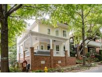 Attractive two-story home featuring a spacious front porch with white railings and a brick foundation at 734 E 10Th St, Charlotte, NC 28202