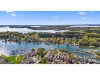 Stunning aerial view of waterfront condos with lake access, boat slips, and manicured lawns under a clear blue sky at 7844 Village Harbor Dr, Cornelius, NC 28031