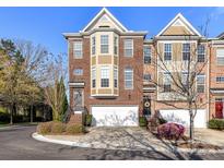 Charming brick townhome featuring a two-car garage, front garden, and inviting entryway for a warm welcome at 7854 Springs Village Ln, Charlotte, NC 28226