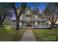 Inviting two-story home with a charming wrap-around porch, mature trees, and meticulous landscaping at 101 E Main St, Cleveland, NC 27013