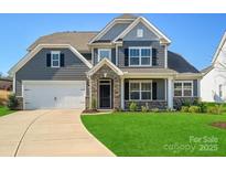 Charming two-story home features a manicured lawn, a two-car garage, and stylish stone accents at 104 Hemlock Cove Ct, Mooresville, NC 28117