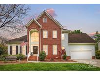 Inviting brick home featuring a manicured lawn, two-car garage, and charming architectural details at 1214 Foxfield Rd, Waxhaw, NC 28173