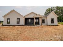 Charming single-story home with a covered porch, black accents and neutral siding, surrounded by a newly mulched lawn at 1429 Coppergate Dr, Salisbury, NC 28147