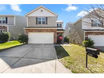 Charming two-story home with a brick and siding exterior, a two-car garage, and a well-manicured lawn at 14328 Evening Flight Ln, Charlotte, NC 28262