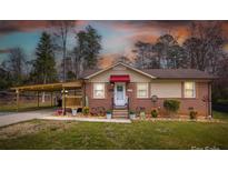 Charming brick home with a red awning, covered carport, and well-manicured lawn at 198 33Rd Nw St, Hickory, NC 28601