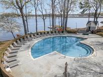 Community pool surrounded by lounge chairs and a scenic lake view at 329 Northwest Dr, Davidson, NC 28036