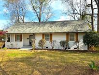 Charming home featuring a freshly painted white brick exterior, new roof, and well-maintained lawn at 3735 Stonehaven Dr, Charlotte, NC 28215