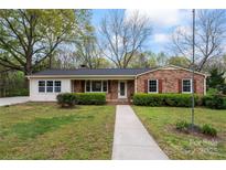 Charming brick home featuring mature trees, manicured shrubs, and a welcoming walkway at 3987 Taxahaw Rd, Lancaster, SC 29720