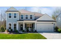 Charming two-story home with light blue siding, white trim, a well-manicured lawn, and an attached two-car garage at 7116 Brookline Pl, Huntersville, NC 28078