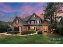 Charming two-story brick home with lush landscaping and inviting entrance at dusk at 8915 Linden Grove Ct, Sherrills Ford, NC 28673