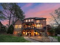 Stunning rear exterior view of a multi-story home with multiple patios and a beautifully landscaped yard at 8915 Linden Grove Ct, Sherrills Ford, NC 28673