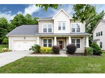 Charming two-story home with a well-maintained lawn, a two car garage, and lovely landscaping at 10125 Loch Lomond Dr, Charlotte, NC 28278