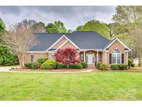Charming brick home featuring a well-manicured lawn, decorative landscaping, and a classic architectural design at 111 Sterling Dr, York, SC 29745