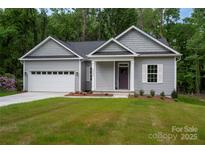 Charming single-story home boasts a manicured lawn, attached garage and a welcoming entrance at 1721 Balfour Ln, Charlotte, NC 28216