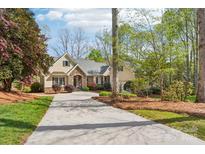 Elegant home with stone accents, manicured landscaping, and a long driveway leading to the residence at 176 Sunset Bay Dr, Troutman, NC 28166