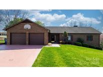 Well-kept brick home with double garage and tidy landscaping, ready for new owners at 3730 Club House Ne Dr, Conover, NC 28613