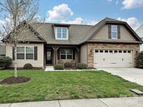 Attractive home showcasing a well-kept lawn, attached two-car garage, and stylish architectural details at 4425 Marlay Park, Indian Trail, NC 28079