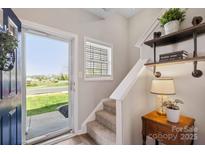 Inviting entryway with natural light and decor, featuring a charming staircase and stylish accents at 5622 Dartington Dr, Indian Land, SC 29707