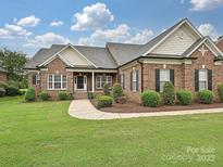 Charming brick home with manicured lawn and inviting walkway to the front door at 6144 Abergele Ln, Matthews, NC 28104