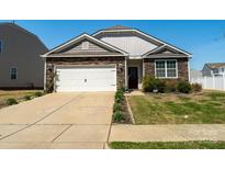 Charming home with stone accents, a well-manicured lawn, and a two-car garage on a sunny day at 6816 Pennyroyal Way, Charlotte, NC 28216