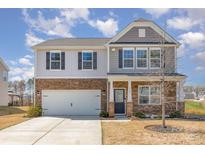 Two-story home featuring a two-car garage, stone accents, and a well-maintained front yard at 715 Saddlebred Ln, Locust, NC 28097