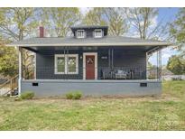 Charming home with a covered front porch and a red front door at 1013 East Dr, Gastonia, NC 28052