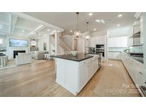 A bright, open kitchen featuring a large island, modern appliances, and hardwood floors at 11036 Shreveport Dr, Huntersville, NC 28078