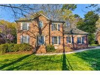 Beautiful brick two-story home with well-maintained lawn, mature landscaping and charming blue shutters at 1537 Wheaton Nw Way, Concord, NC 28027