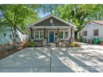 Charming home with a inviting blue front door, stone accents, and a concrete driveway at 2117 Camp Greene St, Charlotte, NC 28208
