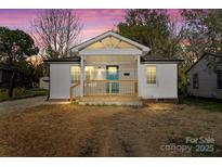 Charming white home featuring a covered front porch with a bright blue front door and a well-manicured lawn at 243 Barber St, Rock Hill, SC 29730