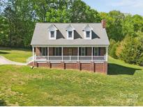 Charming brick home with a covered front porch, dormer windows, and lush green lawn at 2805 Sadler Rd, Alexis, NC 28006