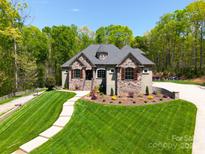 Charming stone-accented home featuring manicured lawn and lush landscaping at 4071 King Wilkinson Rd, Lincolnton, NC 28092