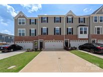 Charming townhome with brick accents, a one-car garage, and a well-manicured lawn at 408 Moondance Dr # C, Gastonia, NC 28054