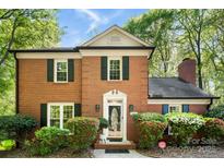 Charming brick home featuring lush landscaping, green shutters, and a classic architectural design at 4522 Woods End Ln, Charlotte, NC 28277