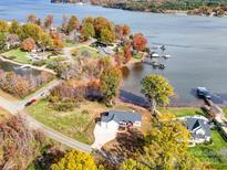 Stunning aerial view of a waterfront home with colorful fall foliage and lake access with docks at 4980 Kiser Island Rd, Terrell, NC 28682