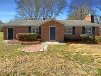 Charming brick home featuring a well-manicured lawn and quaint front porch, with blue shutters at 614 Normandy Rd, Lancaster, SC 29720
