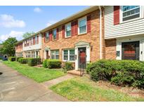 Charming townhomes featuring brick and vinyl siding, red shutters, and well-manicured lawns at 6354 Old Pineville Rd # F, Charlotte, NC 28217