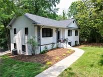 Charming white brick home with a landscaped front yard and walkway to the front porch at 6614 Old Providence Rd, Charlotte, NC 28226