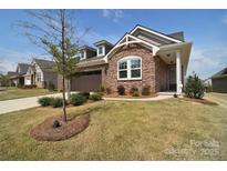 Charming brick home with well-manicured lawn and mature landscaping at 9413 Liberty Hill Dr, Mint Hill, NC 28227