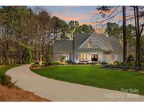 Charming home featuring a manicured lawn, inviting front porch, and a long, winding driveway at 115 Brawley Harbor Pl, Mooresville, NC 28117