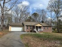 Charming brick home featuring an attached two-car garage and inviting front porch at 1222 Hillsboro Ave, Hickory, NC 28602