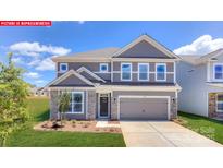 Charming two-story home with gray siding, stone accents, and well-manicured lawn, providing inviting curb appeal at 124 Fordingbridge Ln, Mooresville, NC 28115