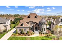 Stunning exterior elevation featuring brick, stone, turret, and mature landscaping at 1311 Sunnys Halo Ln, Waxhaw, NC 28173