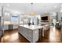 Spacious open kitchen with center island, modern lighting, and seamless flow to living area at 1311 Sunnys Halo Ln, Waxhaw, NC 28173
