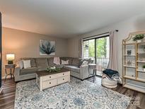 Comfortable living room featuring a large sectional, stylish rug, and sliding glass doors to the outside at 1615 Merry Oaks Rd # G, Charlotte, NC 28205